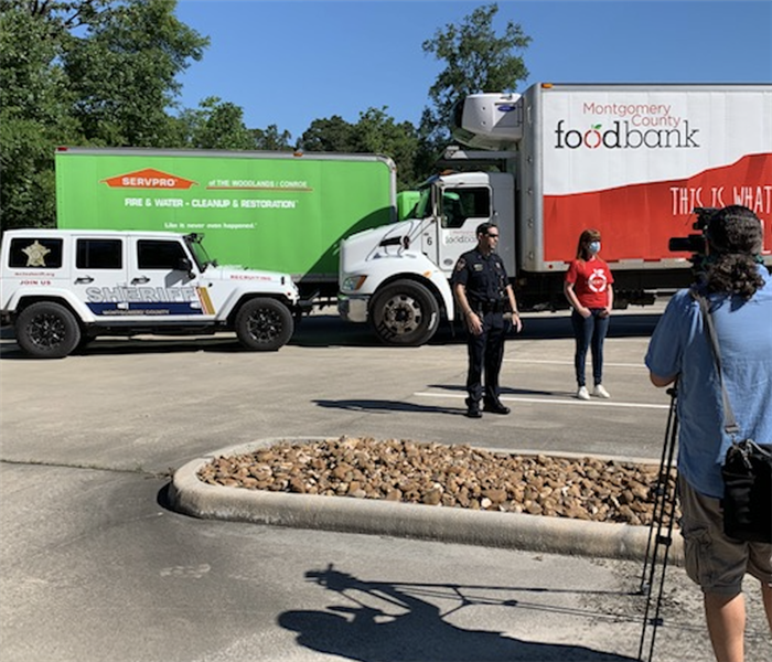 people standing in front of a white and red truck and a SERVPRO truck